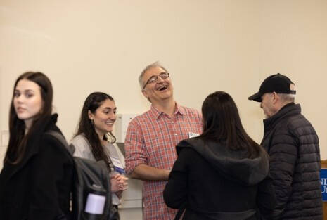Faculty mingling with student researchers and their families